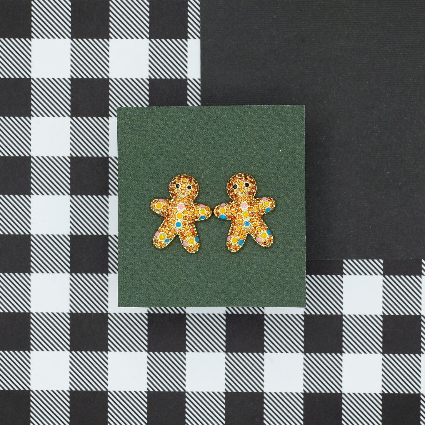 Gingerbread man earrings on a green card with a black and white checkered background