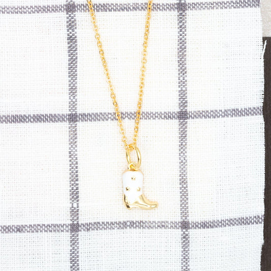 Gold necklace with a pendant on a white and gray checkered cloth