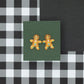 Gingerbread man earrings on a green card with a black and white checkered background