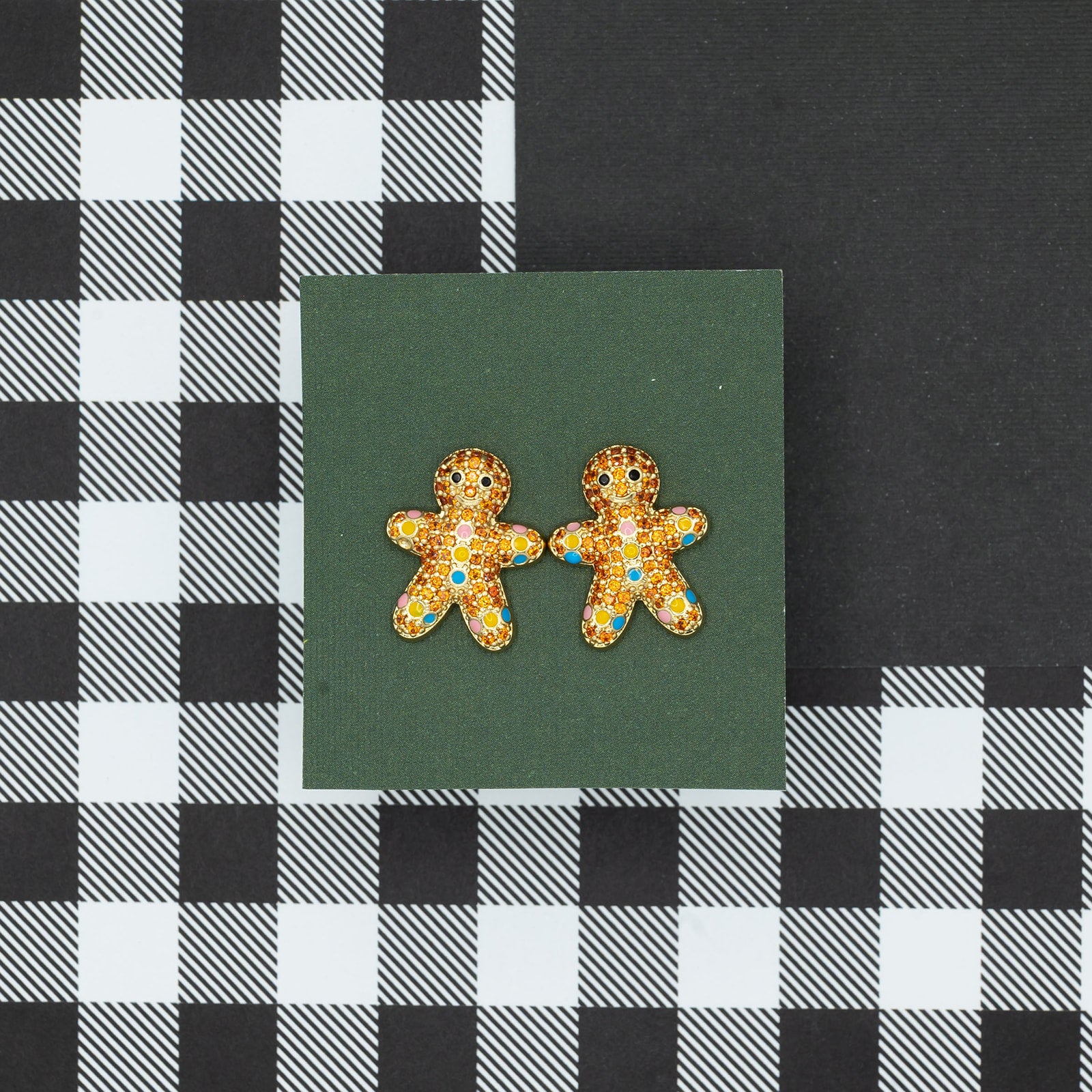 Gingerbread man earrings on a green card with a black and white checkered background